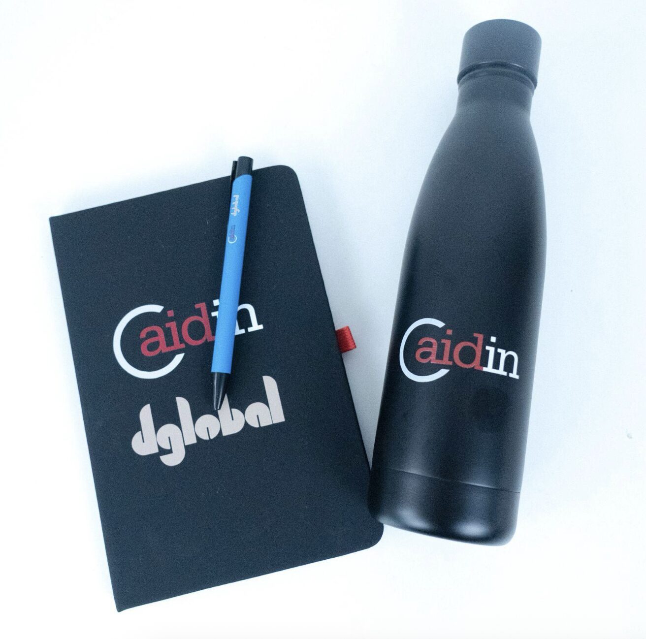 Cuaderno y botella negra con logo "Caidin Global" para merchandising útil.