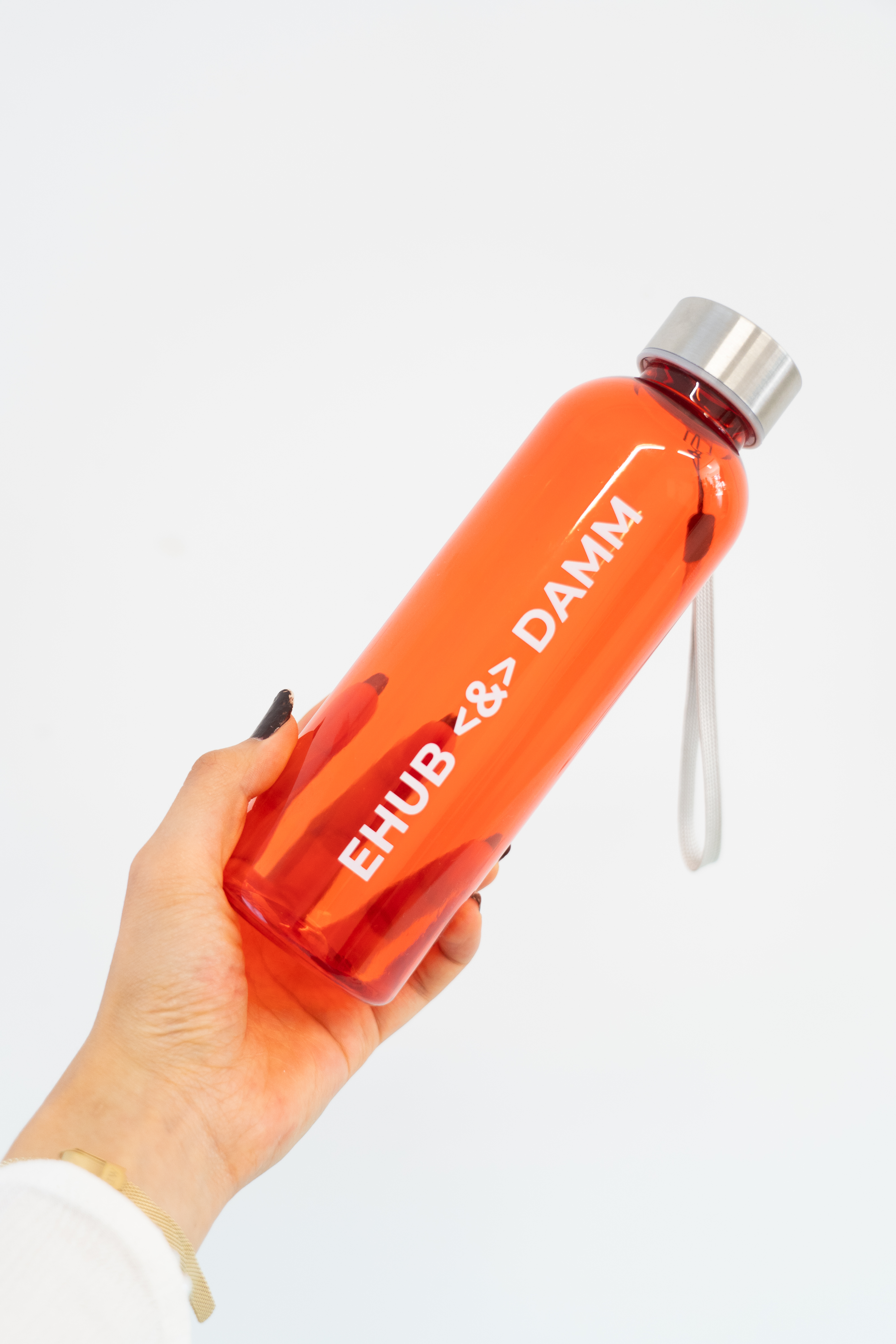 Botella de agua naranja con texto "EHUB DAMM" en un kit de onboarding