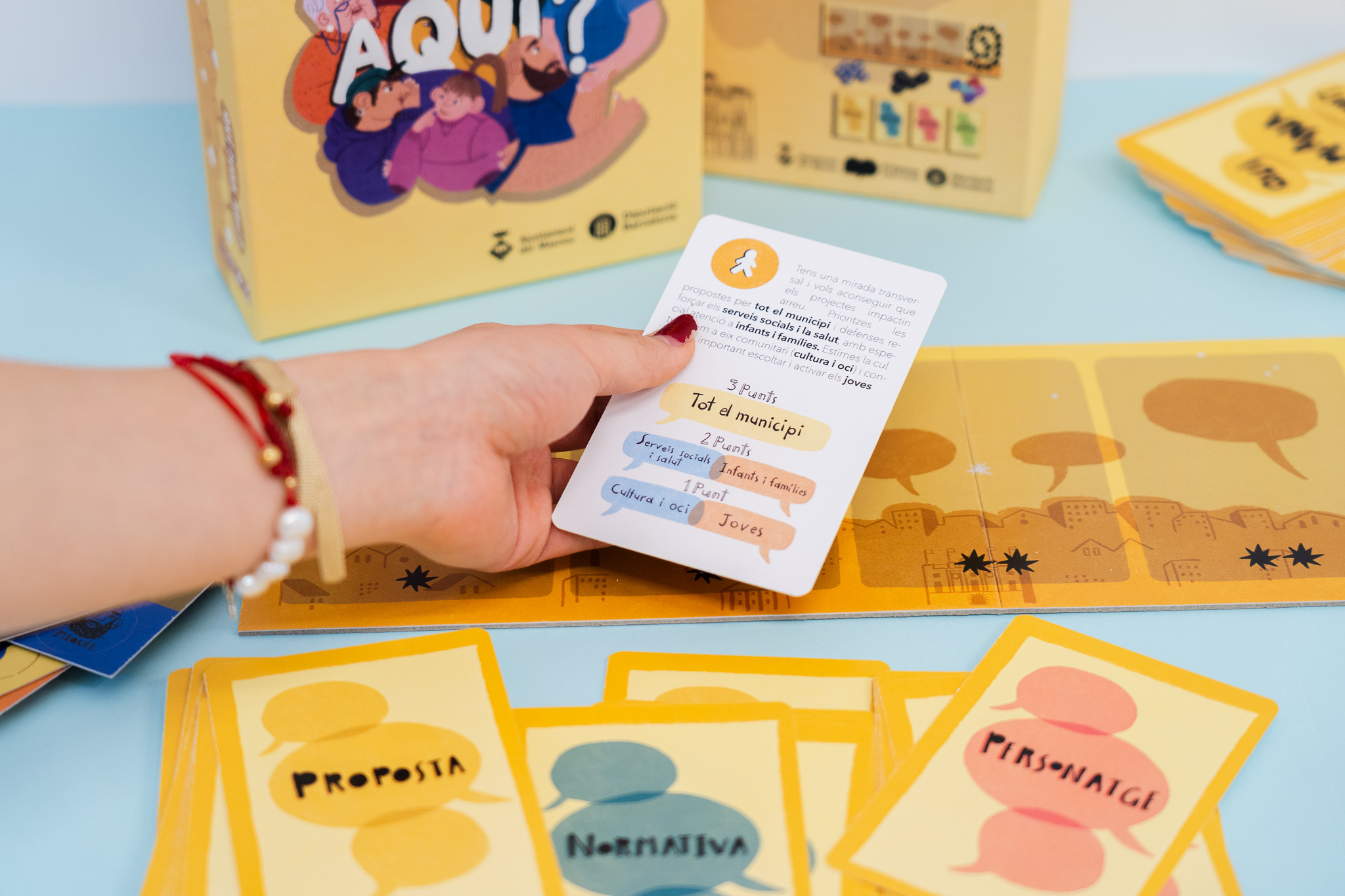 Mano sosteniendo carta de juego de mesa "¿Y si cambiamos las reglas?
