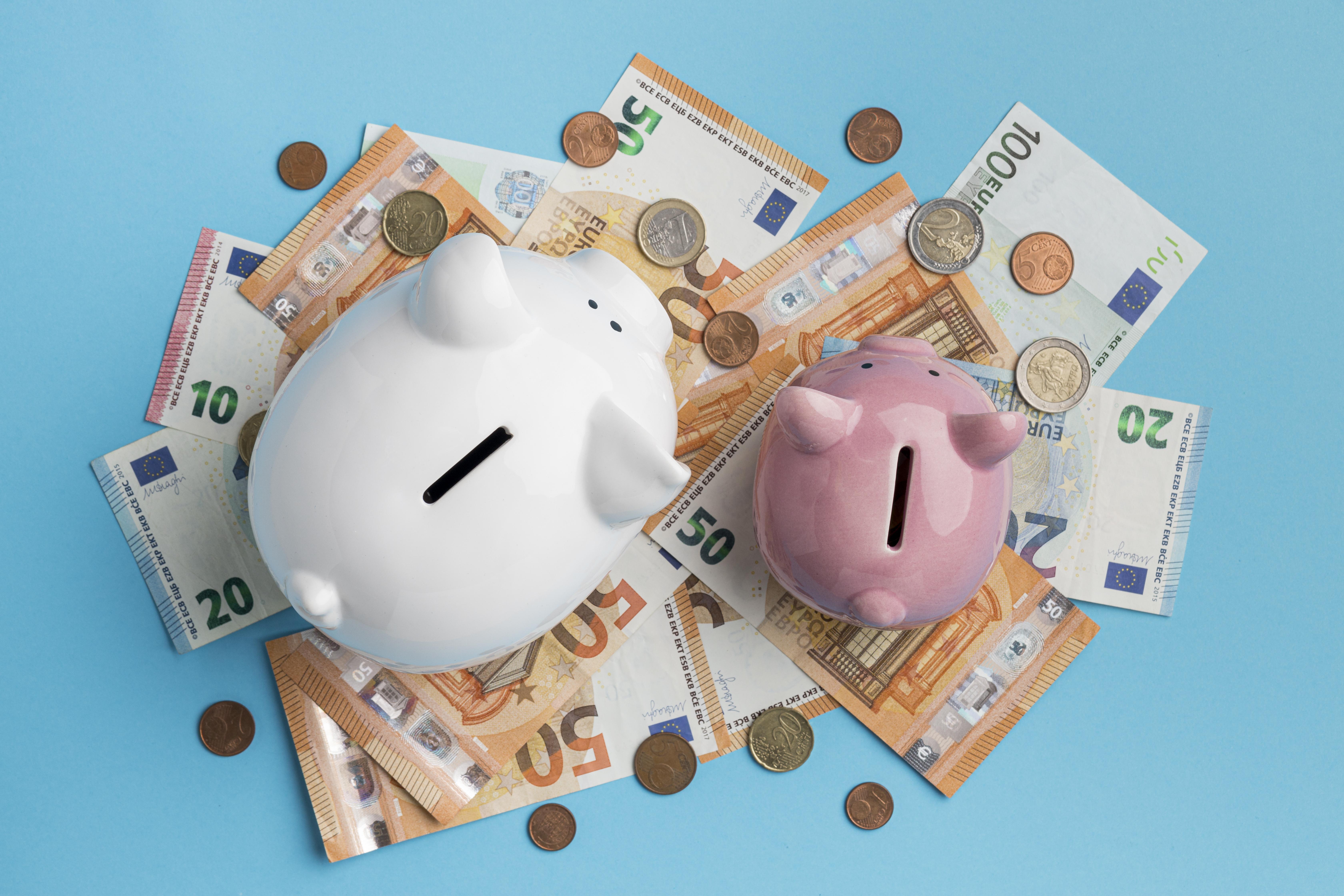 Huchas con billetes y monedas de euros, ahorro y finanzas