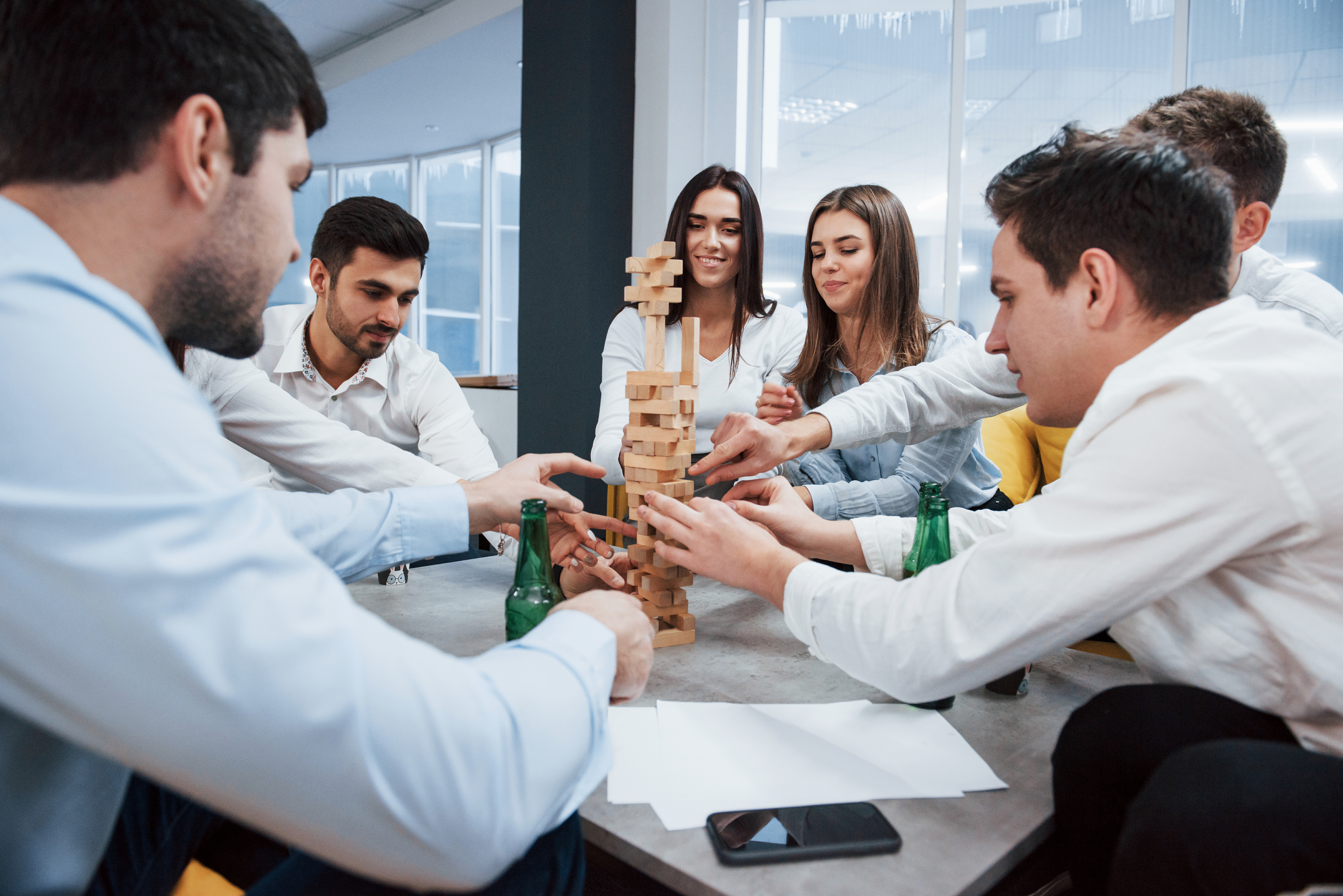 Jóvenes jugando Jenga, estrategia de marca en juegos de mesa.